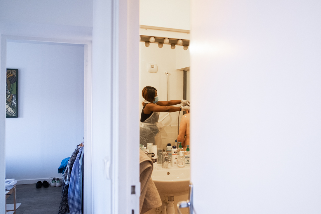 Elle aide le bénéficiaire à prendre une douche. 