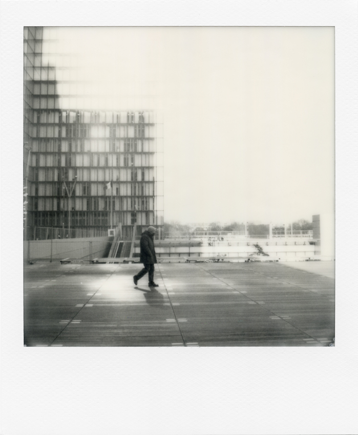 Black and white Polaroid of Paris. A passer-by on the esplanade of the Francois Mitterrand library, Paris, 17 March 2021. Photo by Virginie Merle / Hans Lucas. 
Un passant sur l esplanade de la bibliotheque Francois Mitterrand, Paris, le 17 Mars 2021. Photo de Virginie Merle / Hans Lucas.